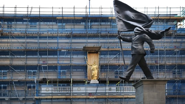 LONDON, ENGLAND - APRIL 29: A new satirical statue attributed to Banksy appears in Waterloo Place on April 29, 2026 in London, England. The sculpture depicts a person in a suit marching forward off a plinth while their face is completely covered by a large, billowing flag. It is located near the Ath