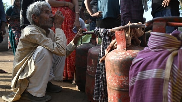 people waiting with empty LPG (liquefied petroleum gas) cylinders for refilling