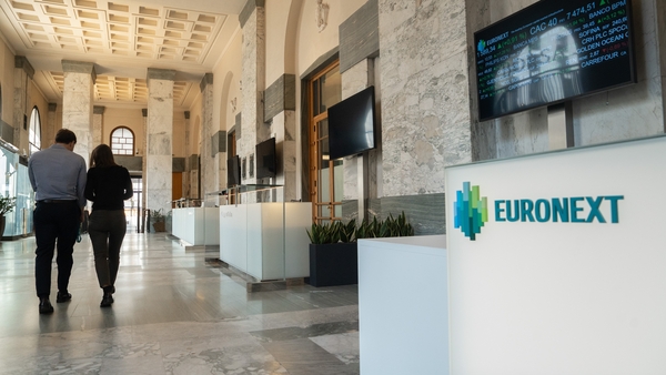 People walk through the reception of Borsa Italiana in Milan with Euronext signage visible