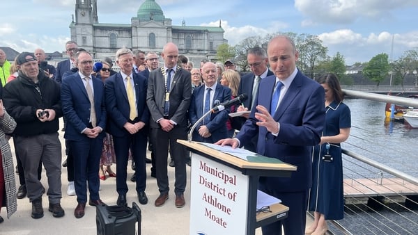 Micheal Martin speaks at a lectern as a number of people listen
