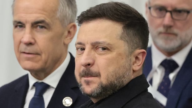 Photo shows Canada Prime Minister Mark Carney beside Ukrainian president Volodymyr Zelensky with an unnamed man in the background 