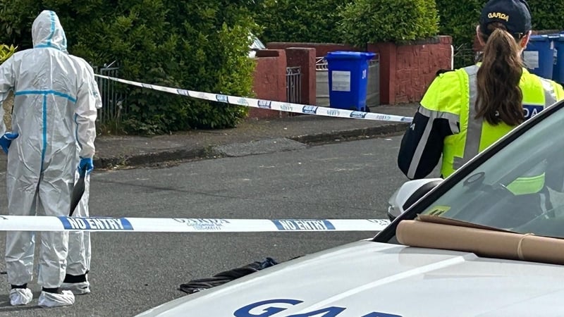 garda forensic officers, crime scene tape and a female garda pictured at a crime scene