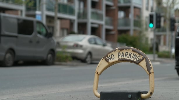 Yellow, metal parking locks have been placed in some spaces