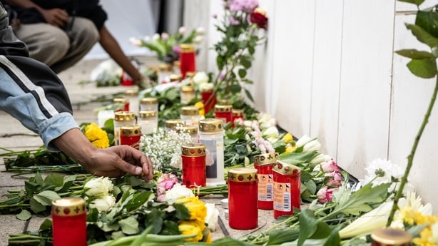 People put down flowers at a makeshift memorial near the scene where the day before a man drove a car into a pedestrian zone, killing two, in Leipzig in eastern Germany