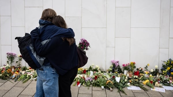 People are mourning near the crime scene where the day before a man drove a car into a pedestrian zone, killing two, in Leipzig in eastern Germany