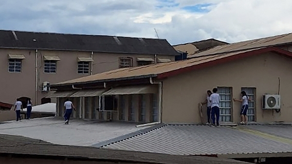 Students of a school take cover on a roof