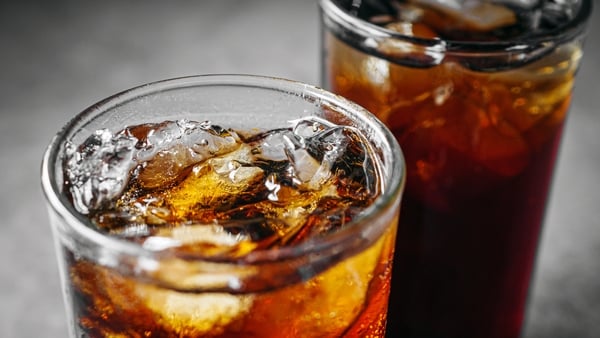 Cola soft drink with ice cubes, Close up of soda fizzy drink in Cold glass on gray background