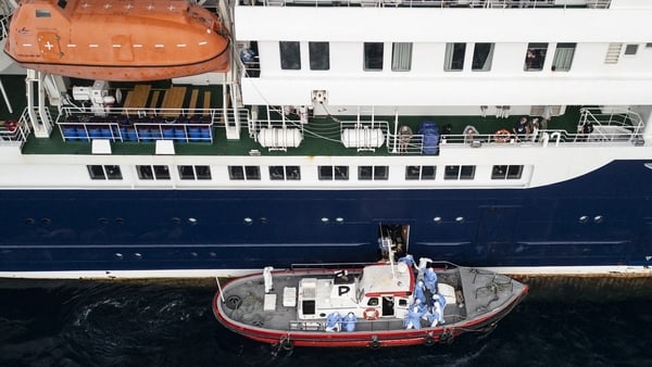 his aerial view shows health personnel assisting patients onto a boat from the cruise ship MV Hondius, while stationary off the port of Praia