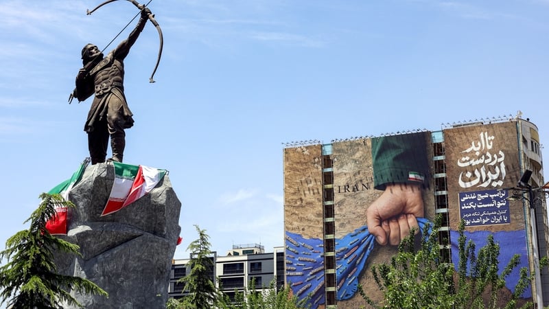 a billboard on the facade of a building depicting the Strait of Hormuz with a caption in Persian reading "Forever in Iran's Hand"