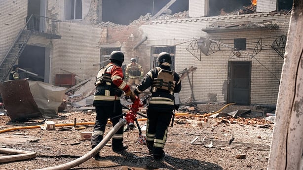 Firefighters work at the site of a Russian drone strike on a kindergarten in Sumy, Ukraine