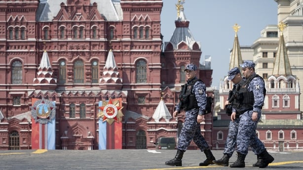 Russian National Guard officers walk across Red Square decorated for the Victory Day military parade in Moscow, Russia