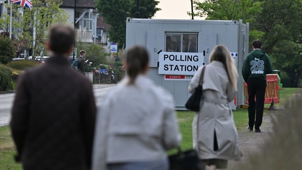 People walk towards a portable polling station in Leigh on Sea, England