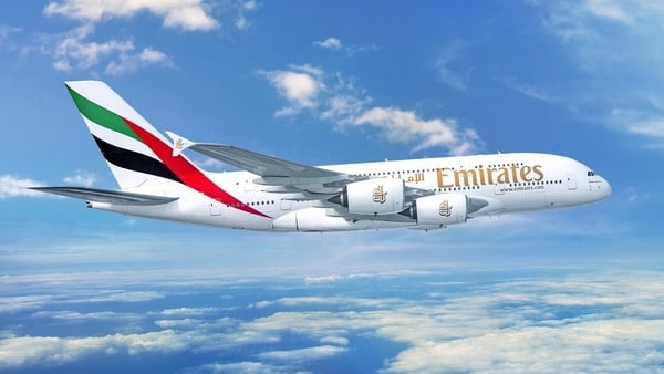 Image of a plane against a blue sky background with the Emirates branding on it