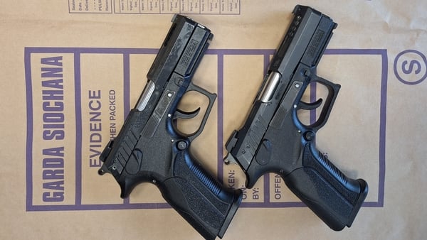 Two semi automatic pistols displayed on a garda evidence bag