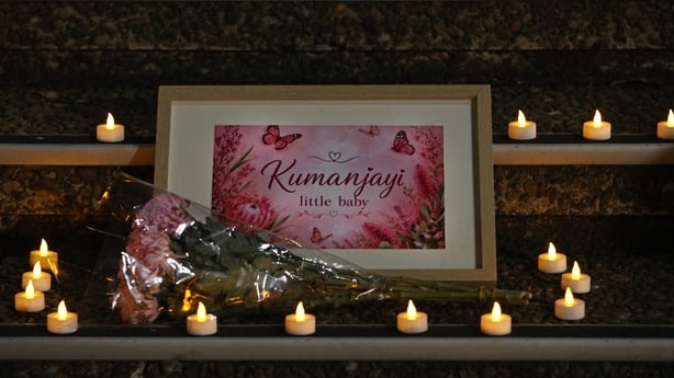 Flowers and candles are placed on steps during a vigil 