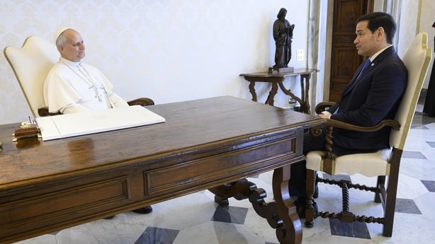 Pope Leo and Marco Rubio pictured sitting at a table in the Vatican