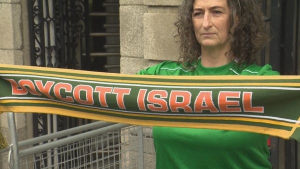 Linn Boylan holds up a boycott Israel scarf