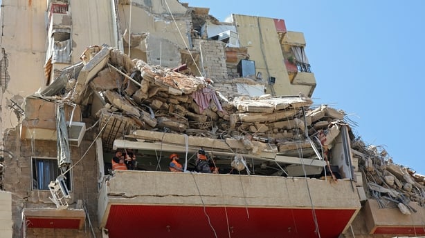 First responders inspect the rubble of a collapsed building following an Israeli airstrike