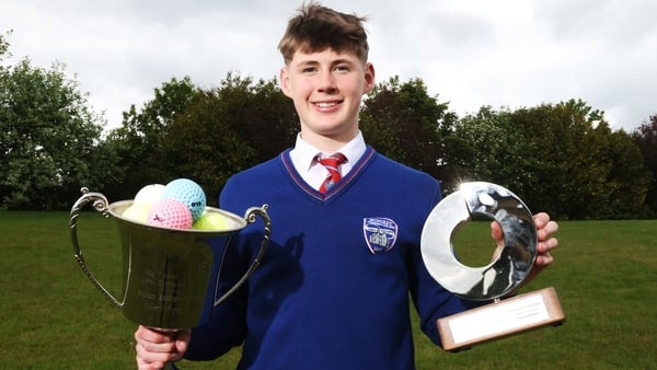 Cathal Sweeney holds his trophies after winning the Student Enterprise award, one trophy contains mutliple glo balls, his winning product