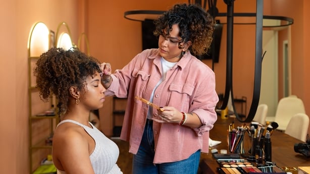 Makeup artist applying makeup on a client's face
