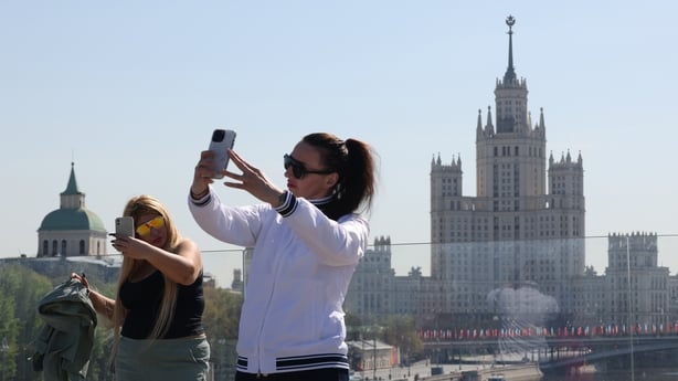 MOSCOW, RUSSIA - MAY 5: A woman takes a selfie photo with her smartphone against the backdrop of a Stalin-era skyscraper, when there is no mobile internet, on May 5, 2026 in Moscow, Russia. Russian mobile operators completely shut down the internet for several hours at the request of the authorities