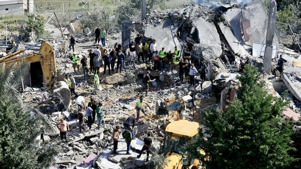 First responders and residents search the rubble for victims at the site of an Israeli airstrike in the southern village of Saksakieh.