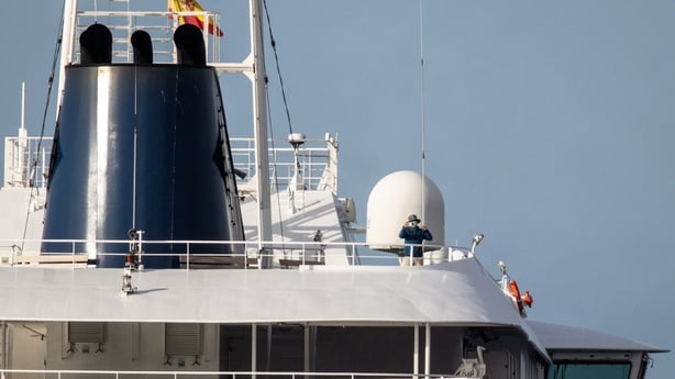 A person uses a phone on the deck of the MV Hondius after docking in the Granadilla Port
