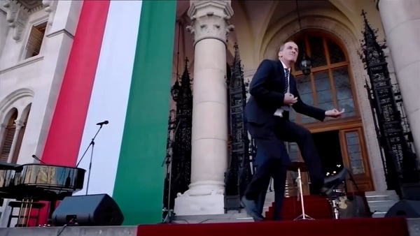 A hungarian politician does an air guitar dance in front of the Hungarian parliament