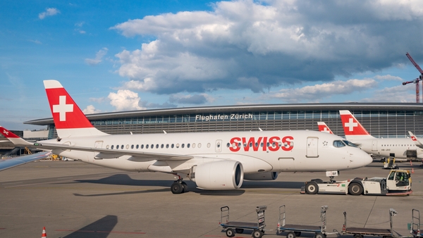 Image of a plane parked on an airport apron with the Swiss Air signage on it
