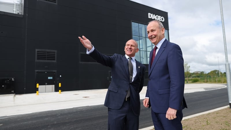 2 businessmen outside a manufacturing facility with the Diageo branding