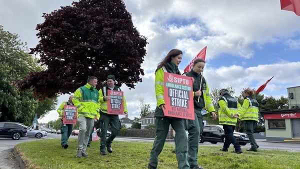 national ambulance service staff holding placards on a picket line in Galway