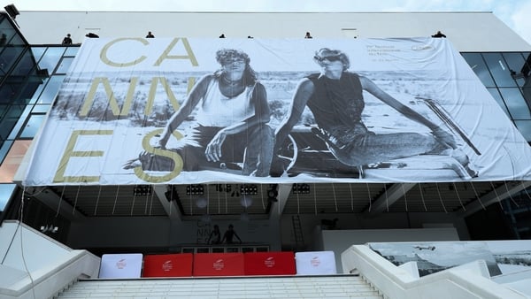 Workers install the official 2026 festival poster, featuring an image of Susan Sarandon and Geena Davis in Thelma & Louise, during the 79th annual Cannes Film Festival on 10 May, 2026 in Cannes, France. (Photo by Aurore Marechal/Getty Images)