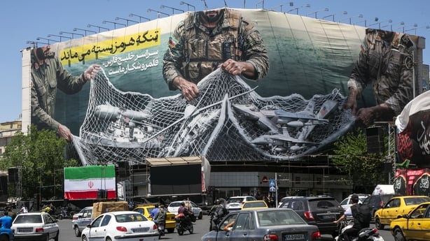 TEHRAN, IRAN - MAY 9: A poster depicts Iranian soldiers holding a net in the shape of the Strait of Hormuz, with US military aircraft ensnared in a fishing net, on May 9, 2026 in Tehran, Iran. There is little sign of progress in negotiations between Iran and the United States, despite both sides' in