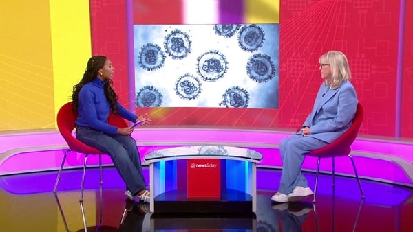 news2day host Florence sits in studio with CMO Prof Mary Horgan with a graphic of a virus in the background.
