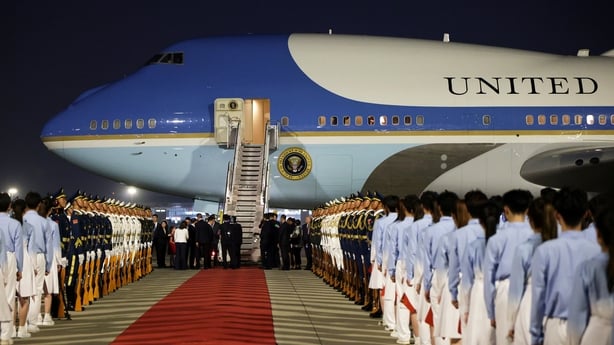 Young people, a military honour guard and military band stand beside air force one in beijing