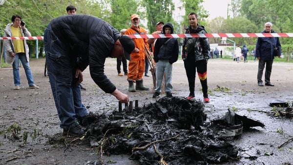 A man inspects fragments of a drone in the courtyard of a residential building following an air attack in Odesa