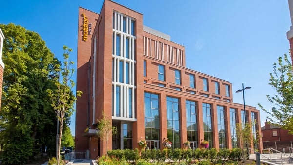 Image of a new redbricked multi-story hotel on a street landscape