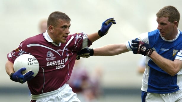 Alan Mangan holds off the challenge from Laois defender Paul McDonald
