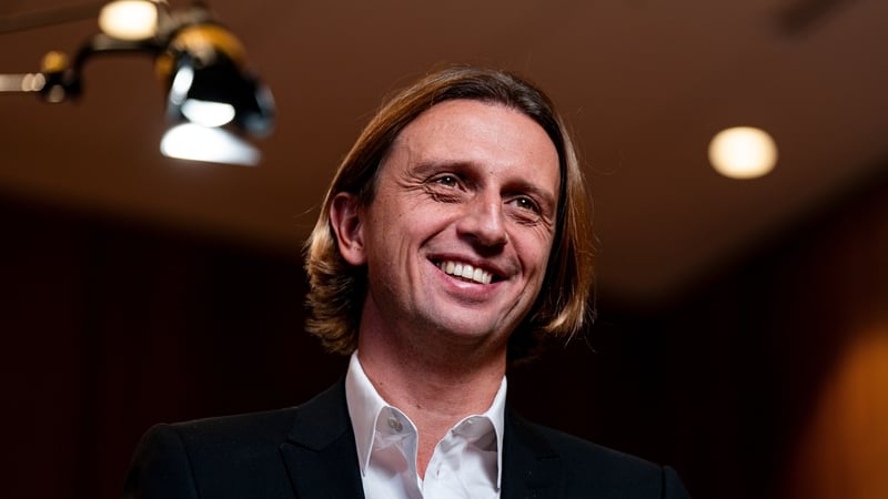 Image of a smiling businessman with an overhead lamp behind him