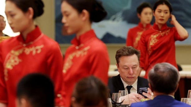 business people attend a dinner in China, with waitresses in red traditional Chinese dress