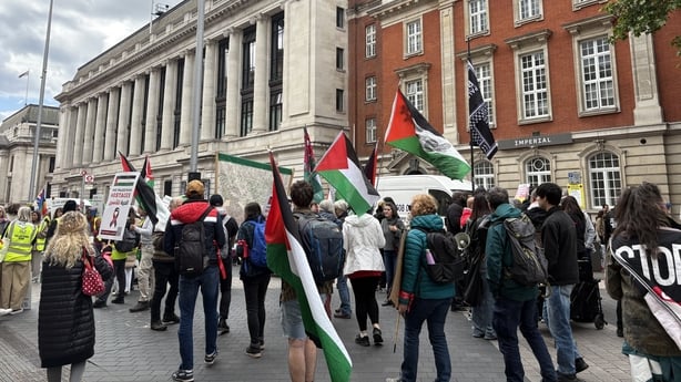 people march holding palestinian flags in london