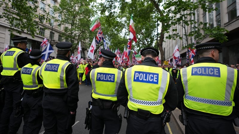 Police officers form a line as protesters gather for the Unite the Kingdom march in London