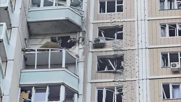 Screen shot from a video shows a high rise apartment building with damaged windows and balconies