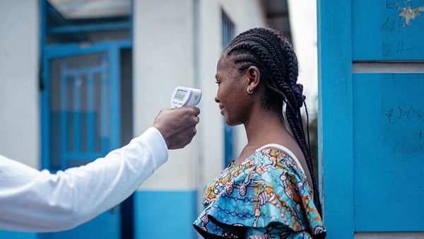 A staff member of the CBCA Virunga Hospital checks a visitor’s temperature using a a contactless infrared thermometer