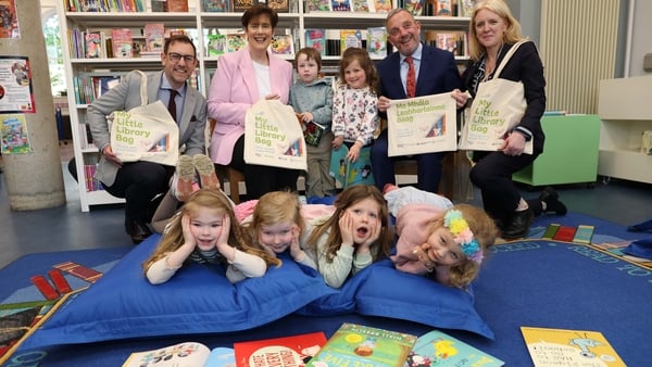 Ministers Foley and Buttimer with members of the LGMA and young children in the foreground launch My Little Book Bag 2026 at a library
