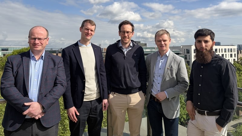 Image of a group of business men posing against a blue sky