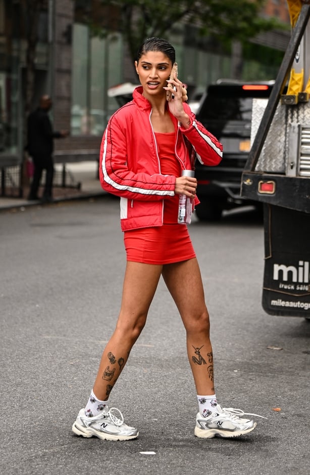 A model is seen wearing a red and white jacket, red dress and white New Balance sneakers outside the Patbo show during womenswear NYFW Spring 2026 on September 16, 2025 in New York City. (Photo by Daniel Zuchnik/Getty Images)