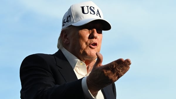 US President Donald Trump gestures as he speaks to reporters after arriving on the South Lawn of the White House