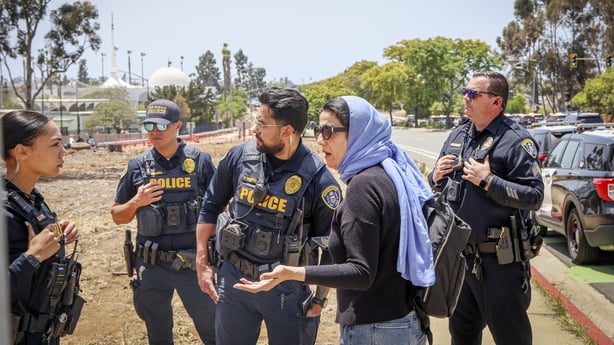 Police interview a woman near the Islamic Center in San Diego after multiple people were killed