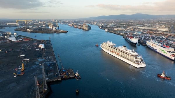 Image of a port with several ships and port cranes with the yellow Harland and Wolff crane in the background